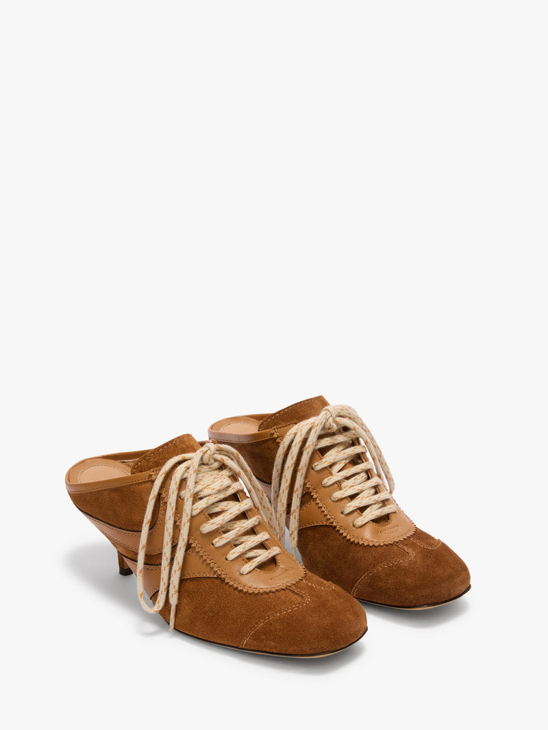 Pair of brown suede shoes with lace-up design on a white background
