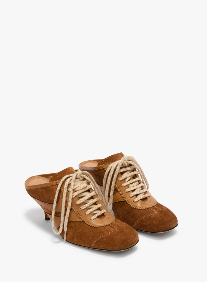 Pair of brown suede shoes with lace-up design on a white background