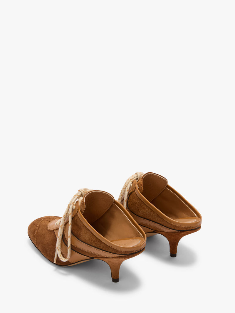 Pair of brown suede shoes with kitten heels on a white background