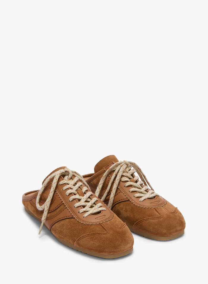 Pair of brown suede shoes with white laces on a white background