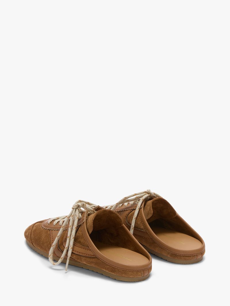 Pair of brown suede shoes with white laces on a white background