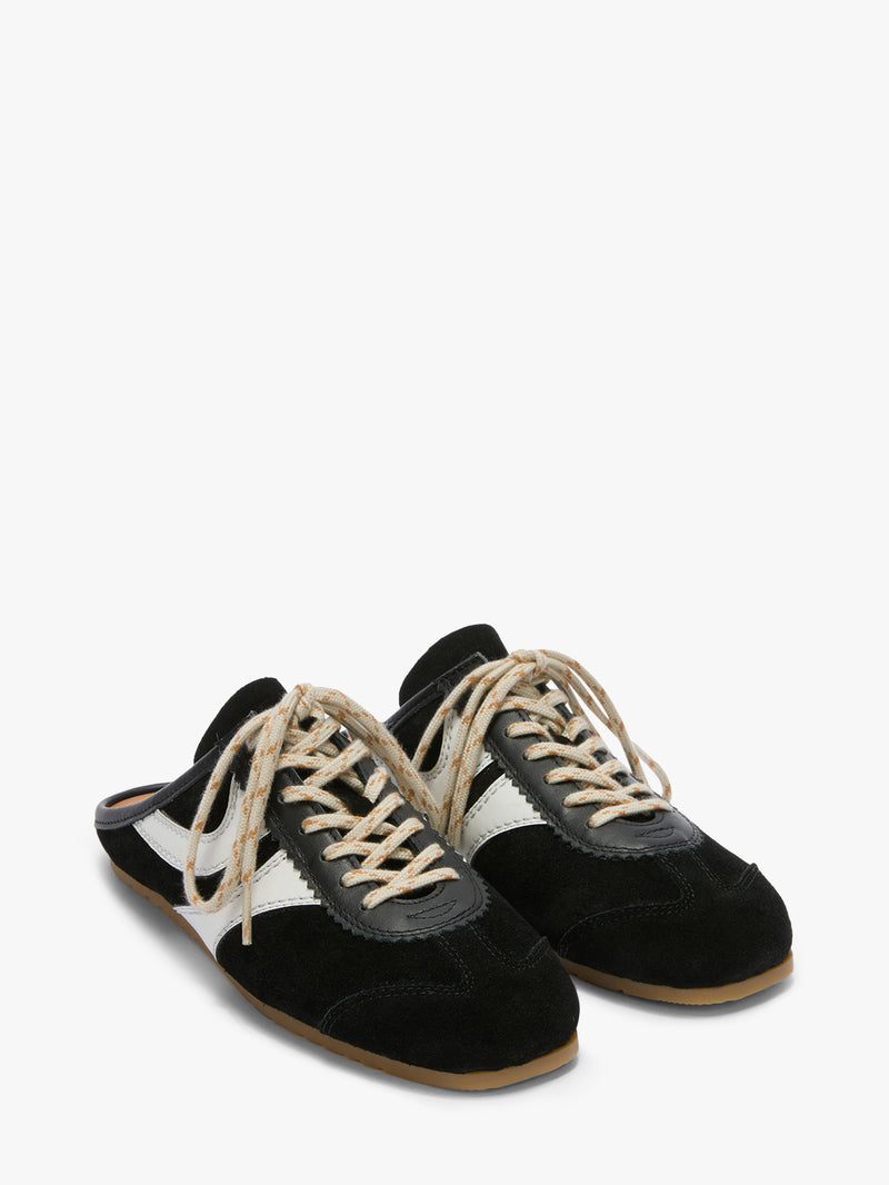 Pair of black and white sneakers with brown soles on a white background