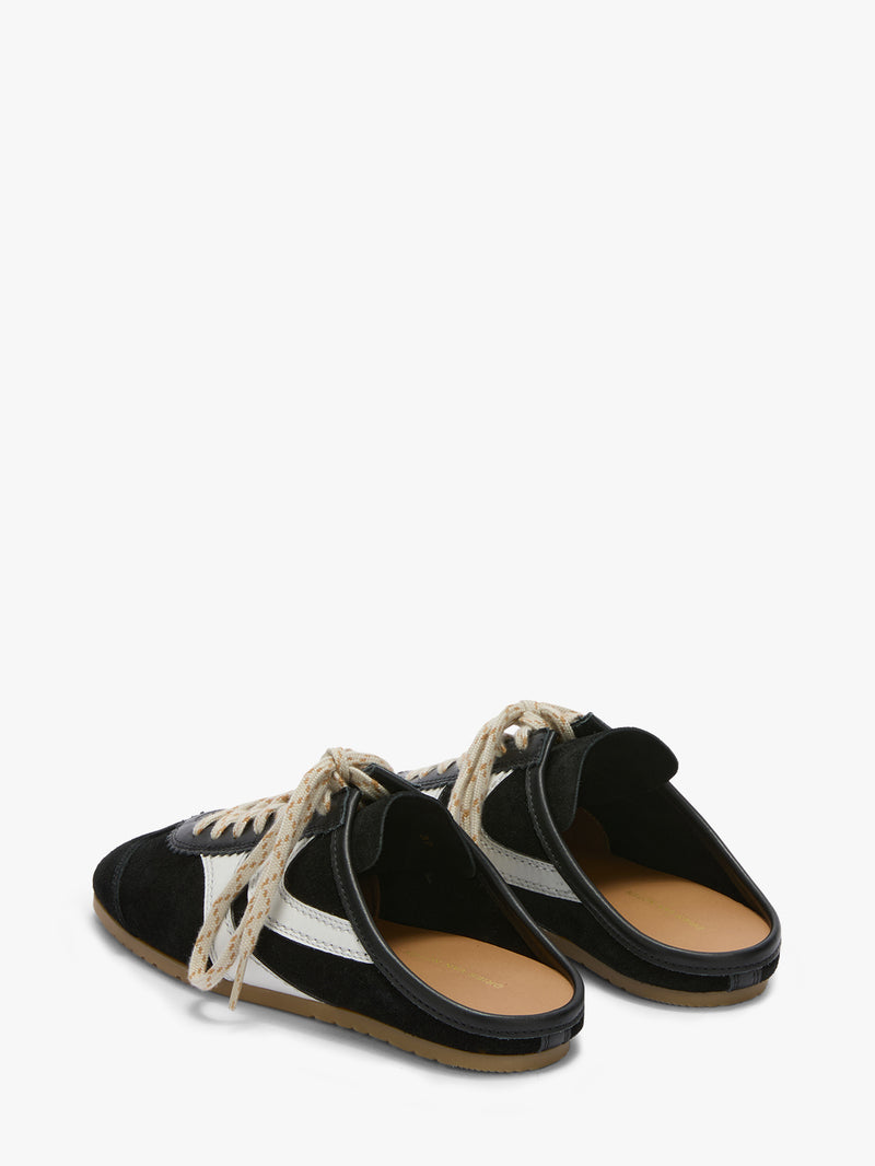 Black and white sandals with tan soles on a white background
