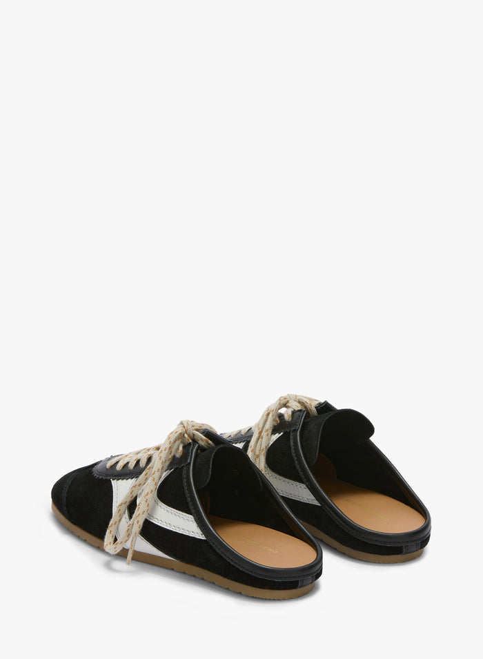 Black and white sandals with tan soles on a white background
