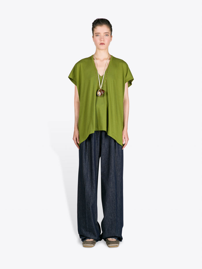 Woman wearing a green top and dark pants on a white background - Dries Van Noten