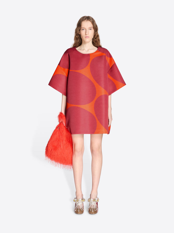 Woman wearing a red and orange dress holding a matching bag on a white background - Dries Van Noten