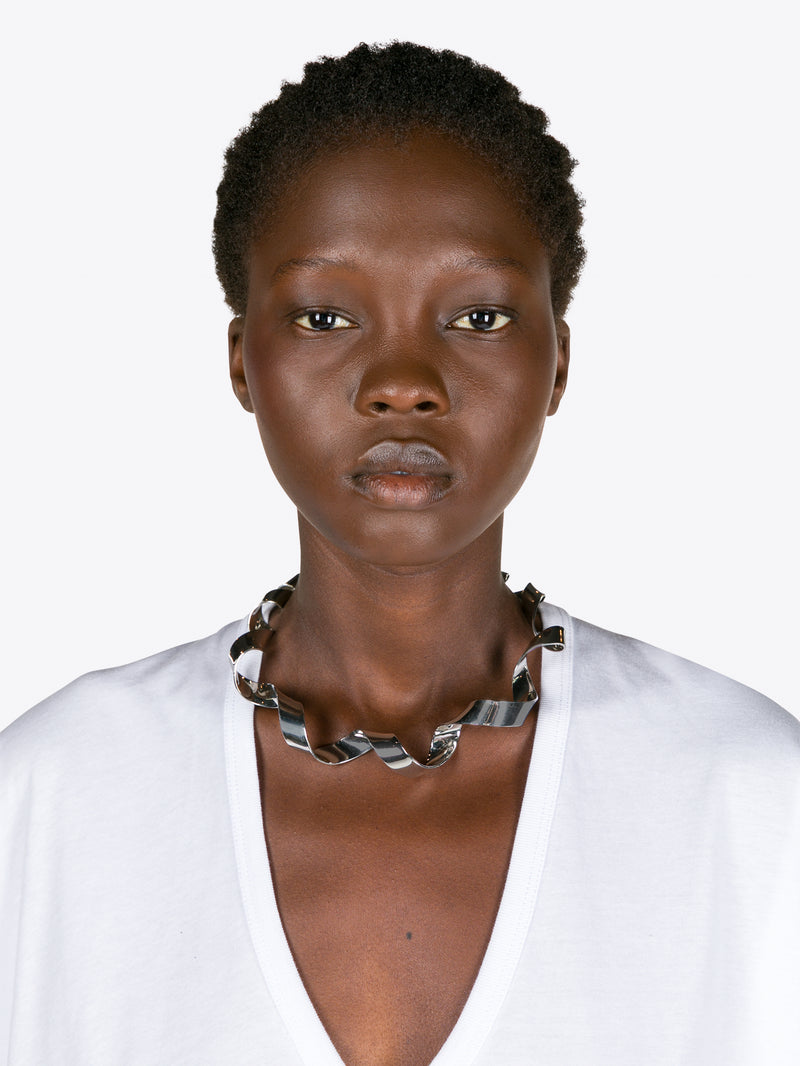 Woman wearing a white top and patterned necklace on a white background - Dries Van Noten