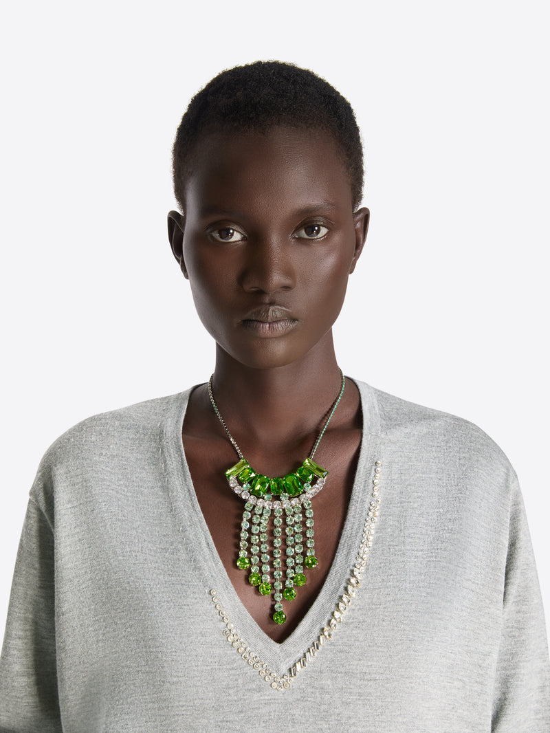 Woman wearing a gray sweater and green necklace with a white background - Dries Van Noten