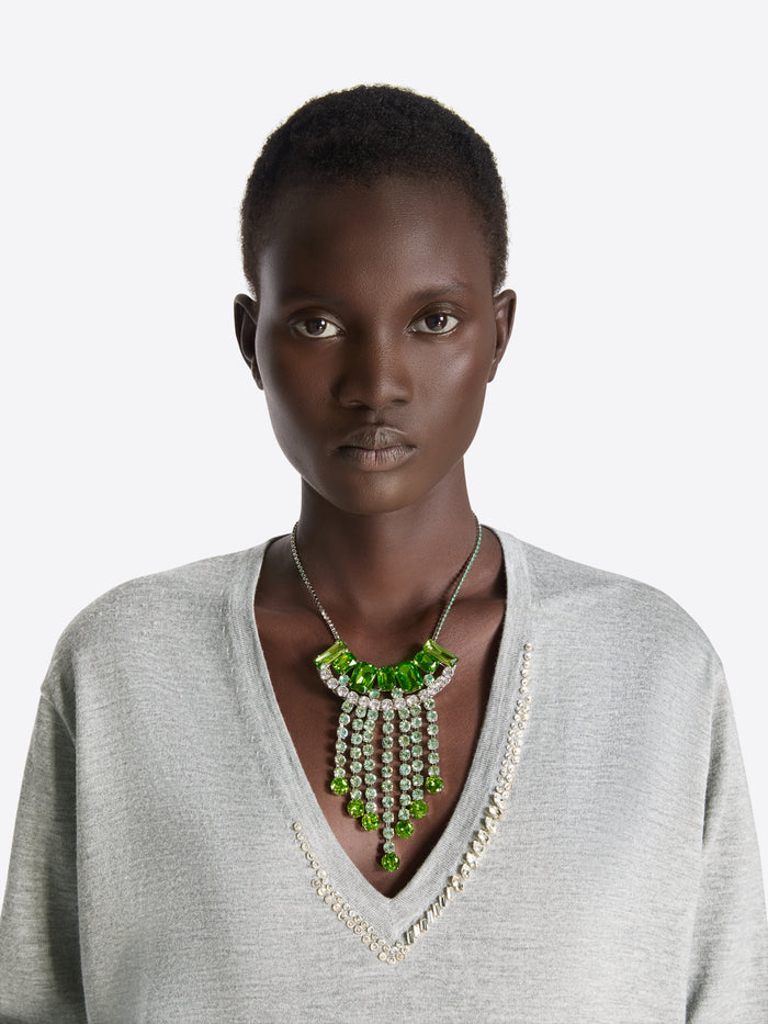 Woman wearing a gray sweater and green necklace with a white background - Dries Van Noten