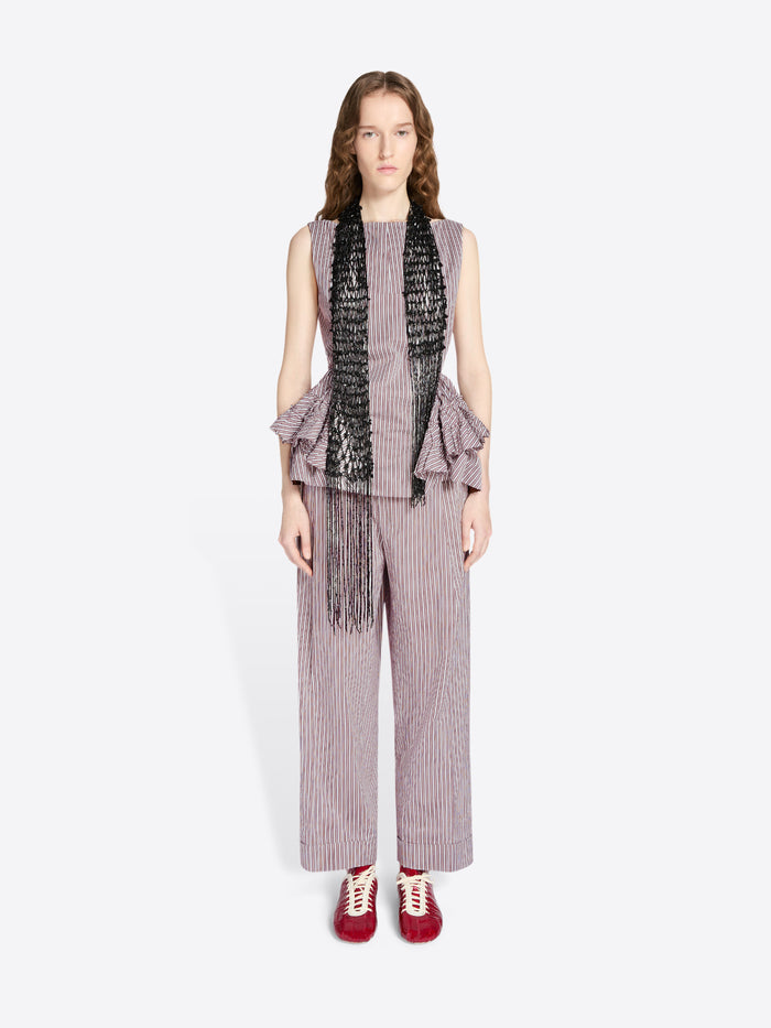 Woman wearing a sleeveless ruffled top with a scarf and wide-leg pants on a white background - Dries Van Noten