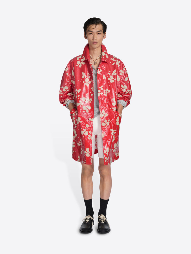 Person wearing a red floral raincoat on a white background