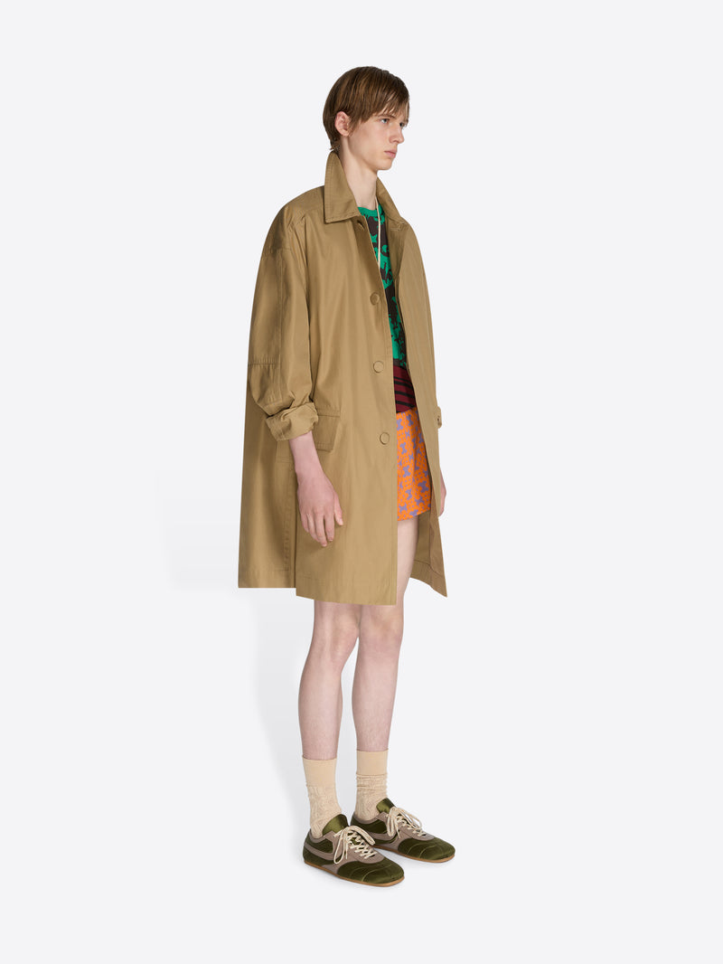 Person wearing a beige trench coat on a white background - Dries Van Noten