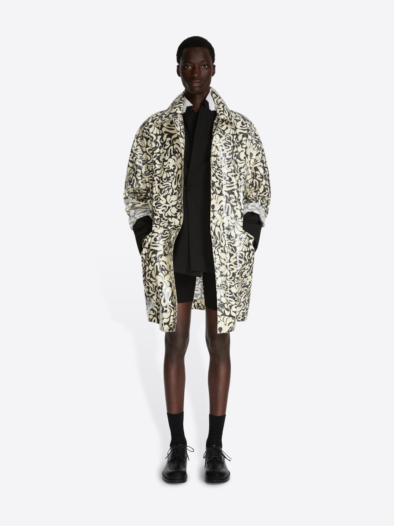 Person wearing a patterned coat on a white background - Dries Van Noten
