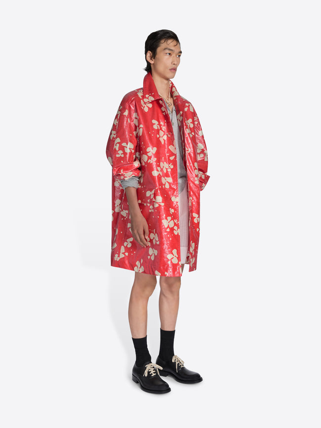 Person wearing a red floral coat on a white background