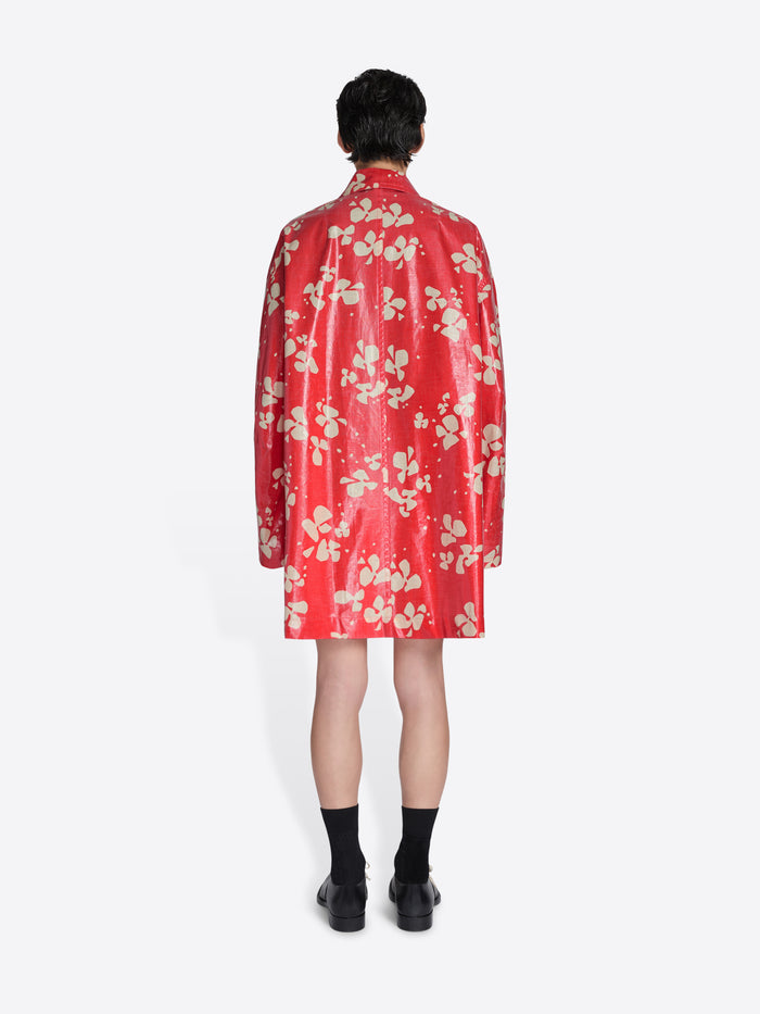 Person wearing a red floral raincoat on a white background