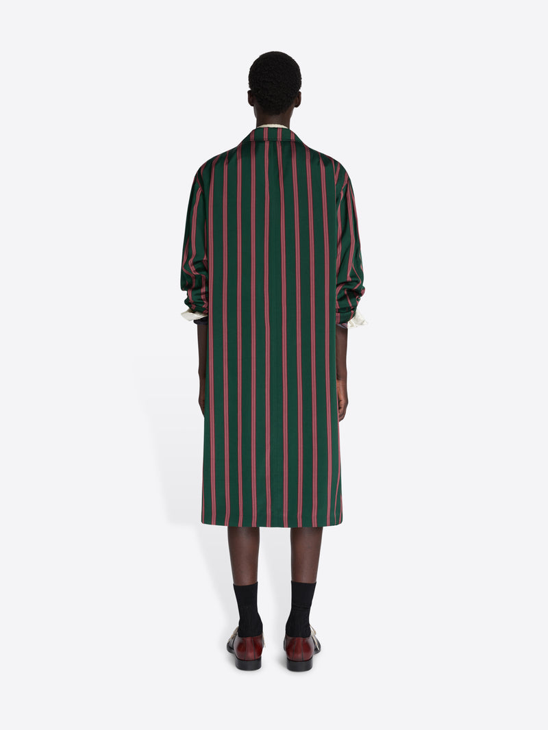 Person wearing a green and red striped dress on a white background