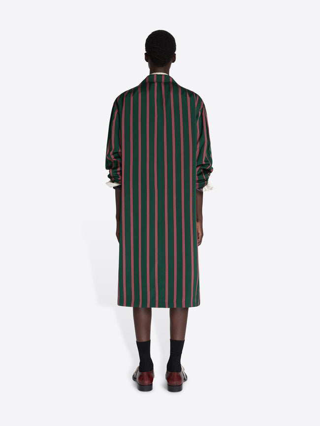 Person wearing a green and red striped dress on a white background