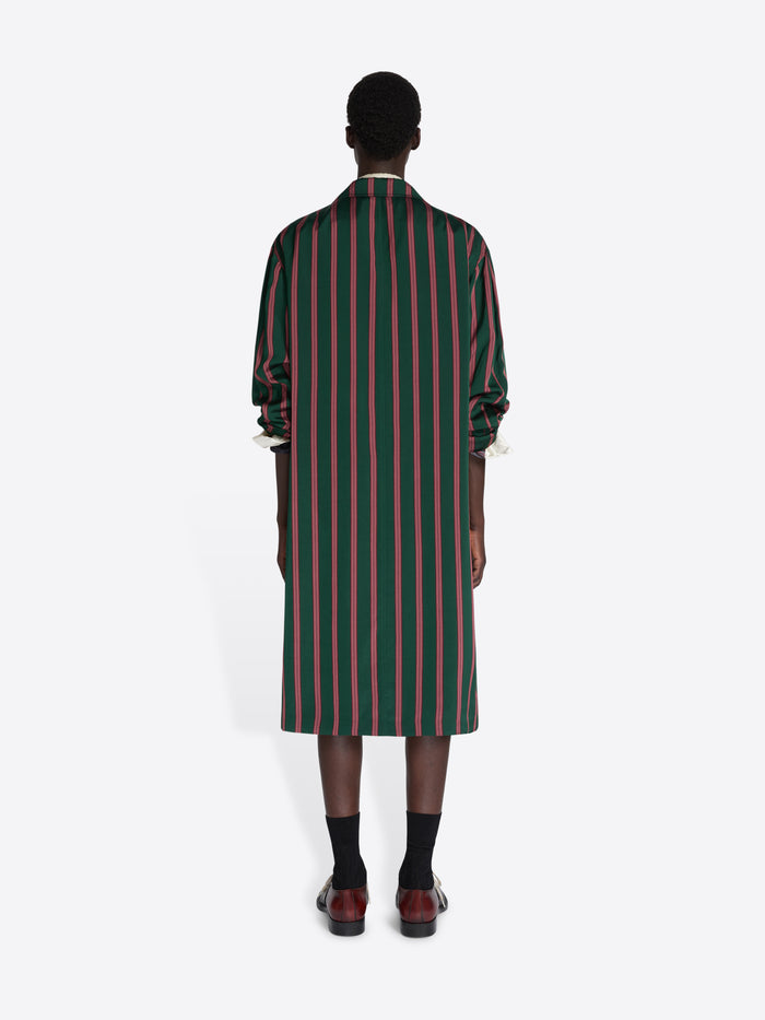Person wearing a green and red striped dress on a white background