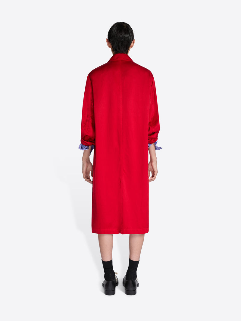 Person wearing a red coat with long sleeves on a white background