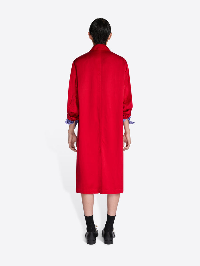 Person wearing a red coat with long sleeves on a white background