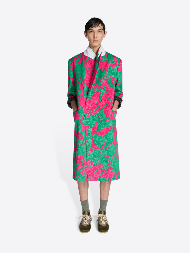 Person wearing a colorful coat with pink and green patterns on a white background - Dries Van Noten