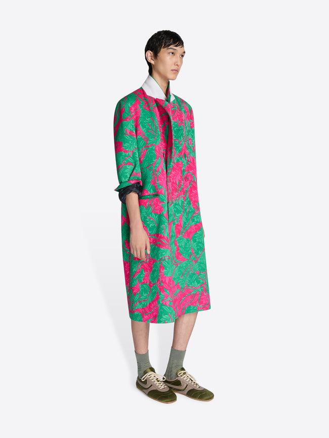 Person wearing a colorful floral coat on a white background - Dries Van Noten