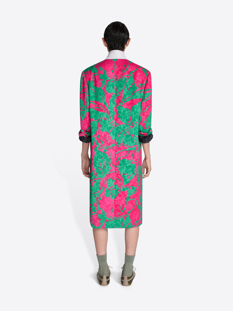 Person wearing a vibrant pink and green patterned coat on a white background - Dries Van Noten