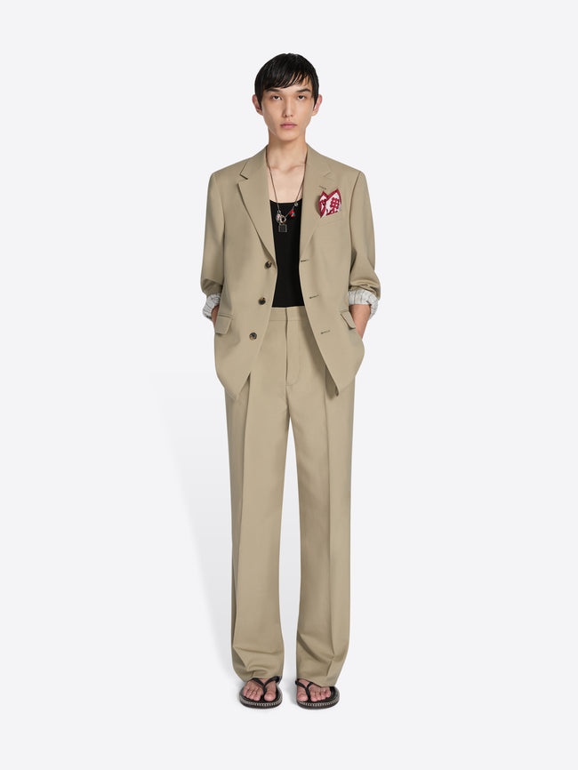 Person wearing a beige suit with a white background