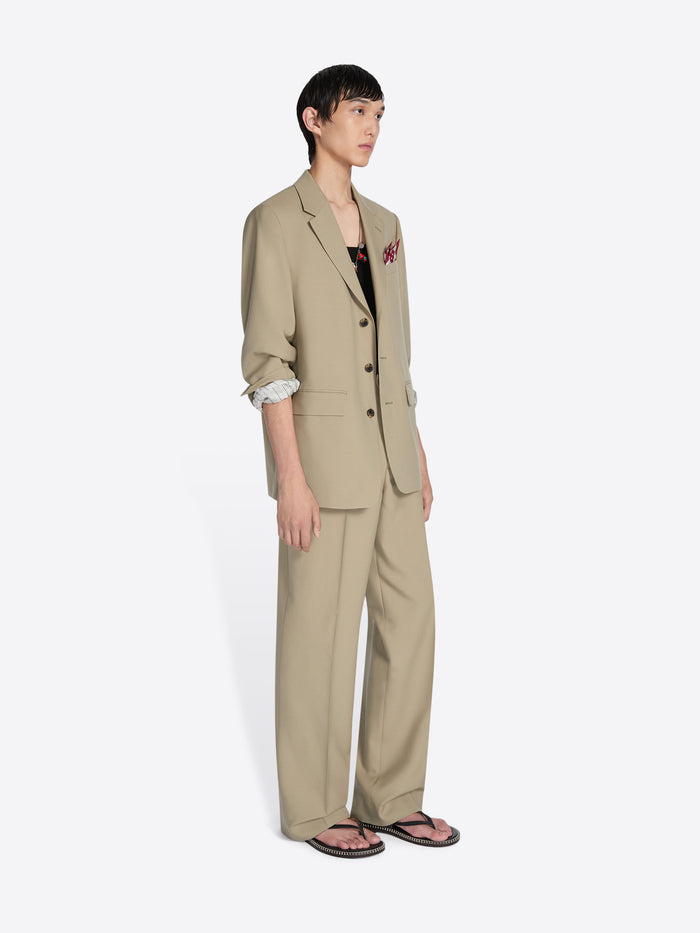 Person wearing a beige suit on a white background