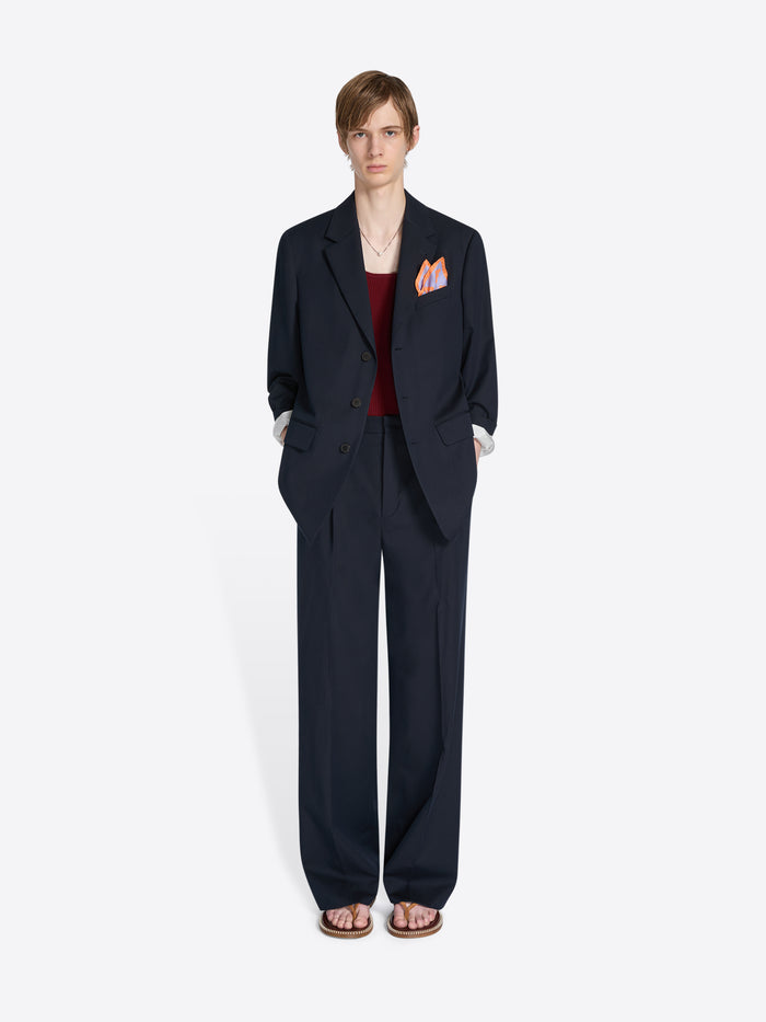 Person wearing a navy suit with a white background