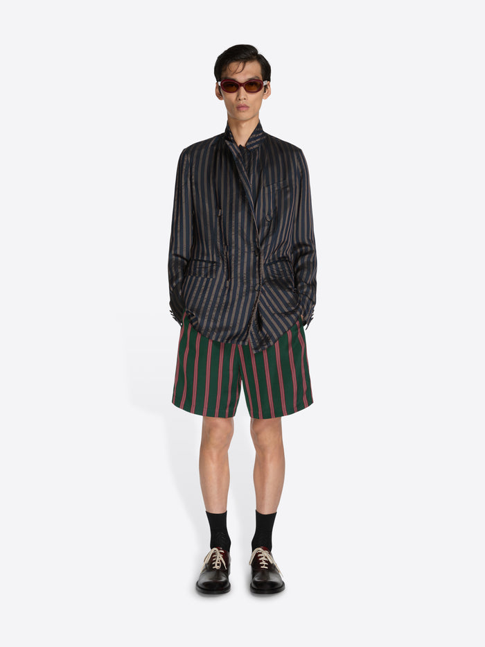 Person wearing a striped shirt and shorts on a white background - Dries Van Noten