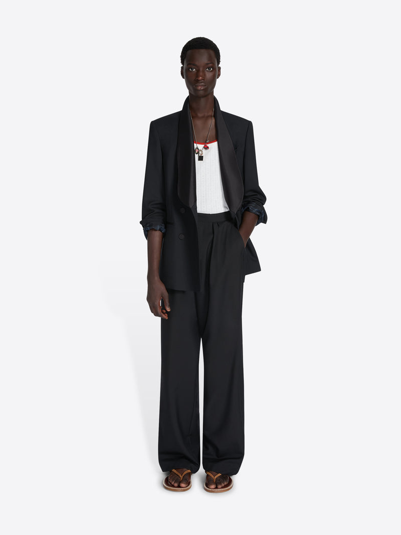 Person wearing a black suit with a white shirt on a white background - Dries Van Noten
