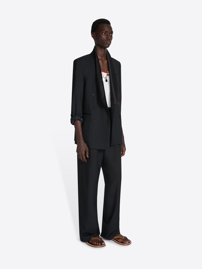 Person wearing a black suit on a white background - Dries Van Noten