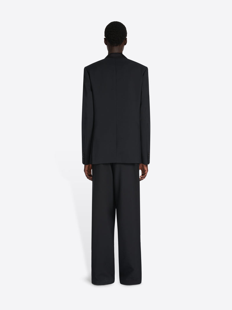 Person wearing a black suit on a white background - Dries Van Noten