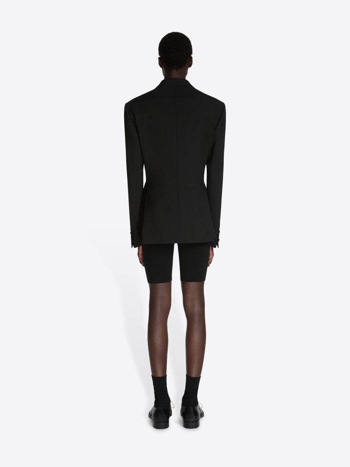 Person wearing a black blazer and black shorts on a white background - Dries Van Noten