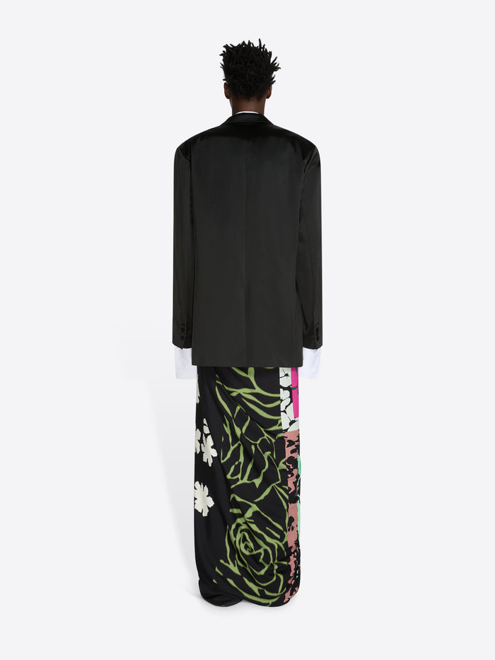 Person wearing a black outfit with floral patterns on a white background