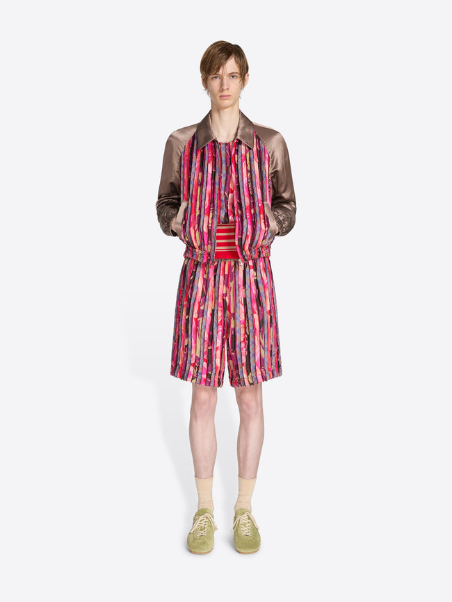 Model wearing a colorful dress with a patterned jacket on a white background - Dries Van Noten