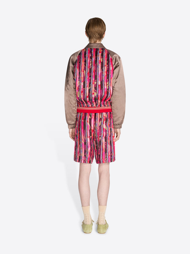 Person wearing a patterned outfit with a jacket and dress on a white background - Dries Van Noten