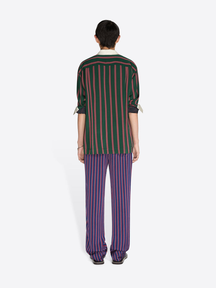 Person wearing a green and red striped shirt with matching pants on a white background