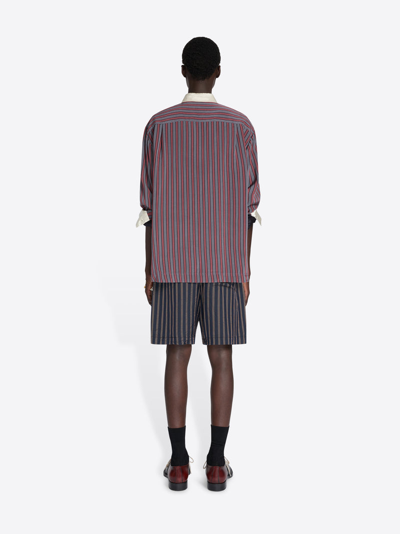 Person wearing a striped shirt and shorts set on a white background