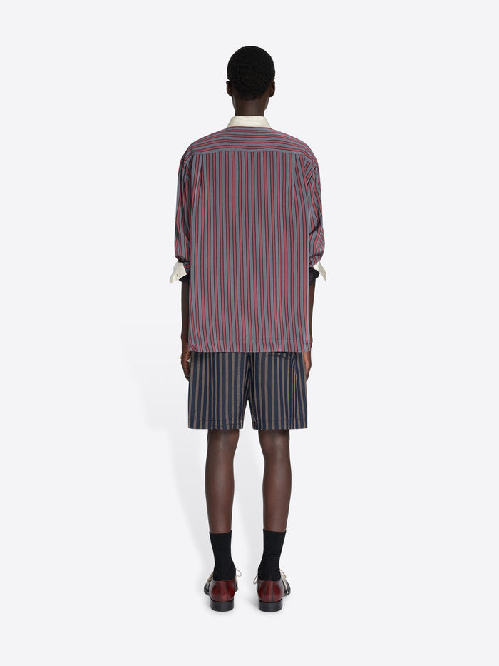 Person wearing a striped shirt and shorts set on a white background