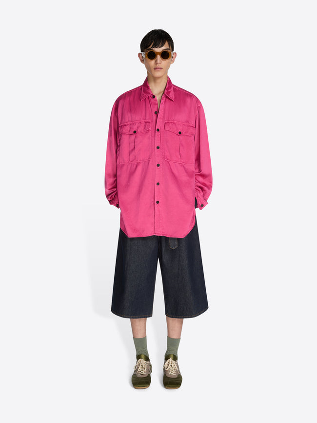 Person wearing a bright pink jacket and black pants on a white background - Dries Van Noten