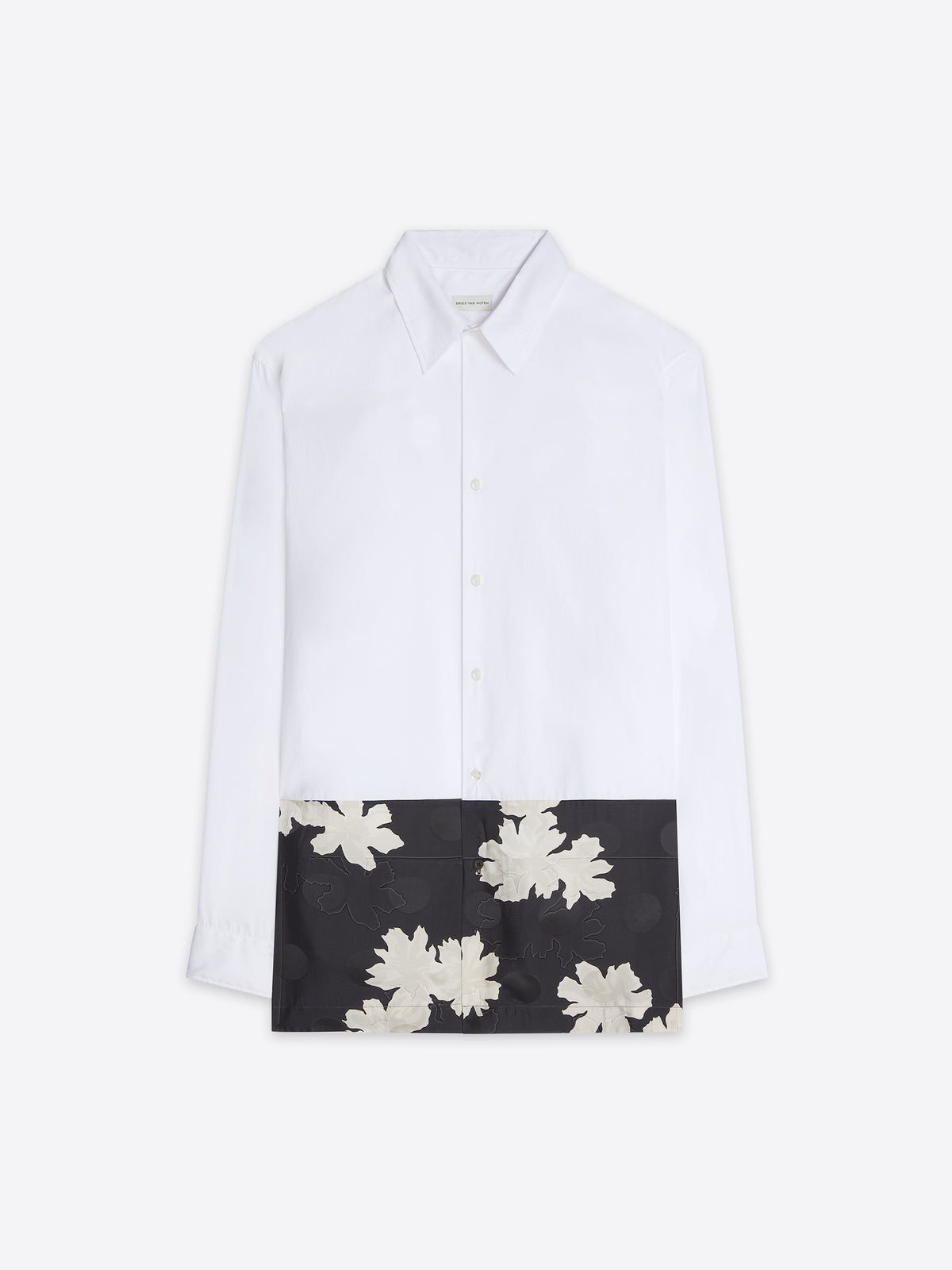 White shirt with a black panel featuring white floral patterns on a white background