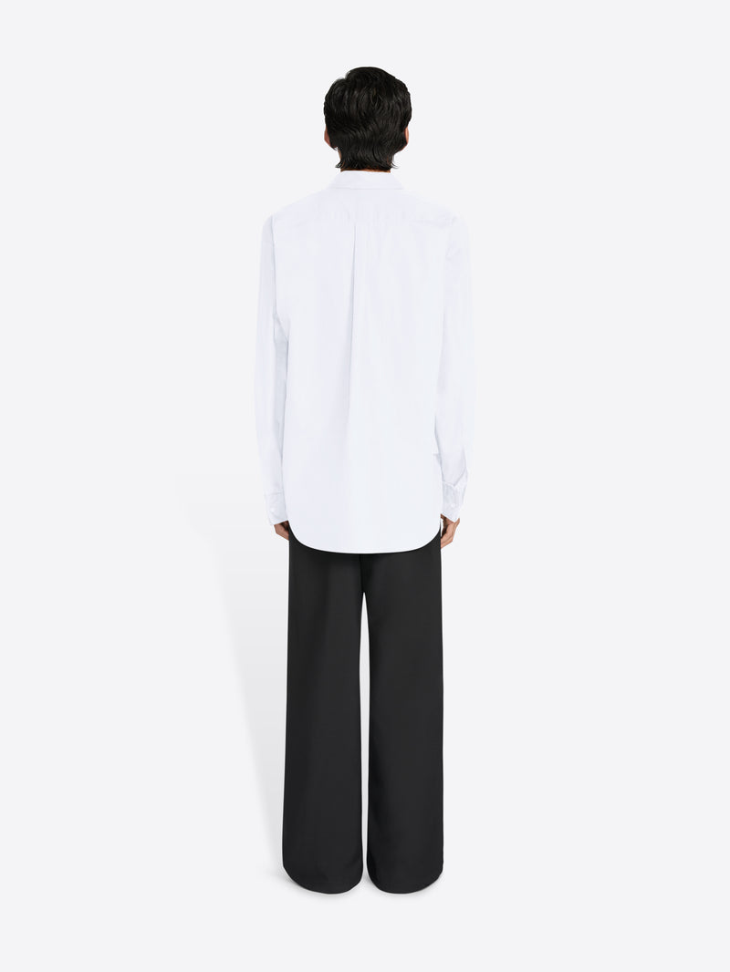 Person wearing a white shirt and black pants on a white background