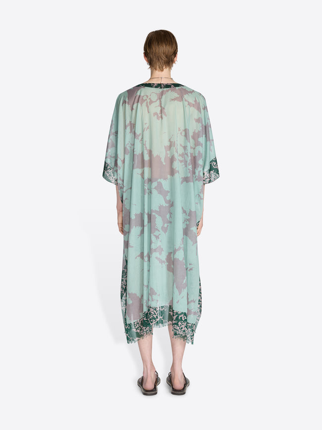 Person wearing a light green floral dress on a white background