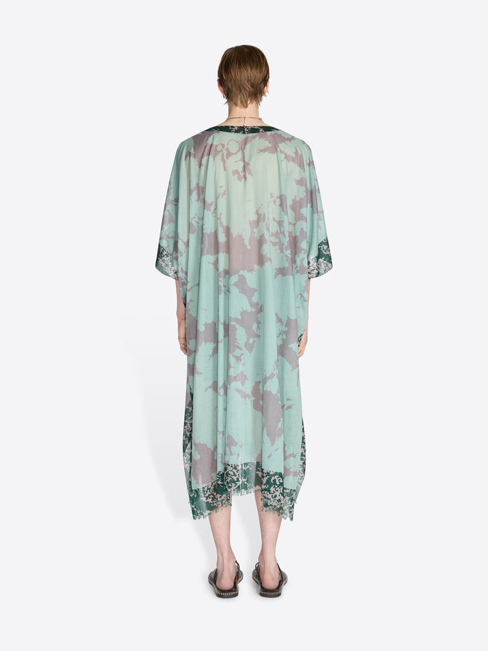 Person wearing a light green floral dress on a white background