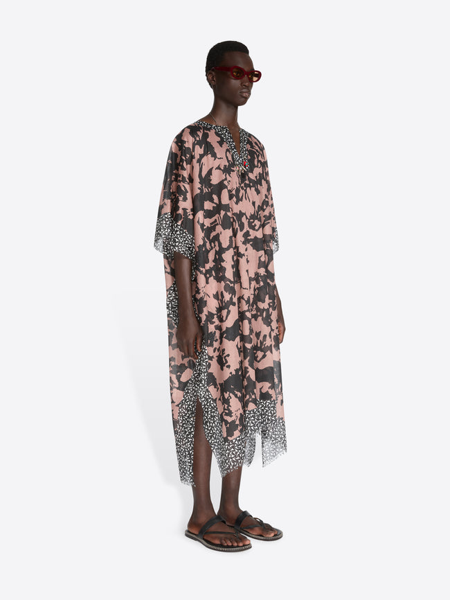 Μan wearing a floral dress with a white background