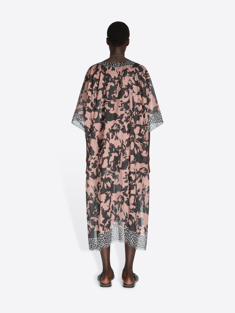 Person wearing a floral patterned dress on a white background