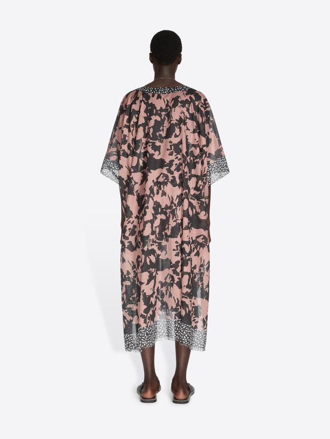 Person wearing a floral patterned dress on a white background