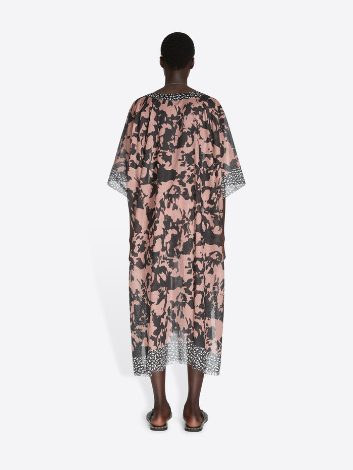 Person wearing a floral patterned dress on a white background